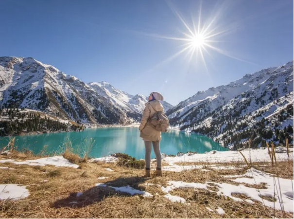 A person standing near the Big Almaty Lake